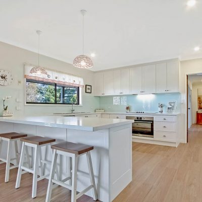Bilpin Shaker Kitchen with white stone benchtop and breakfast bar and silver handles and whit cabinets