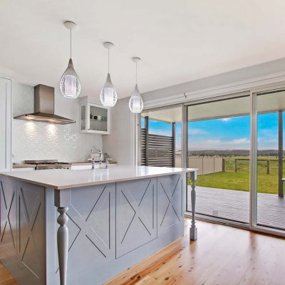Country Style Shaker Kitchen with white stone island benchtop and carved wooden legs