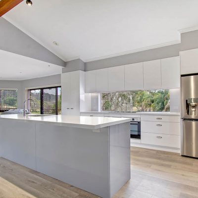 Pitt Town Modern Flat Panel Kitchen with glass splashback window silver handles and island benchtop cabinetry and stainless steel appliances