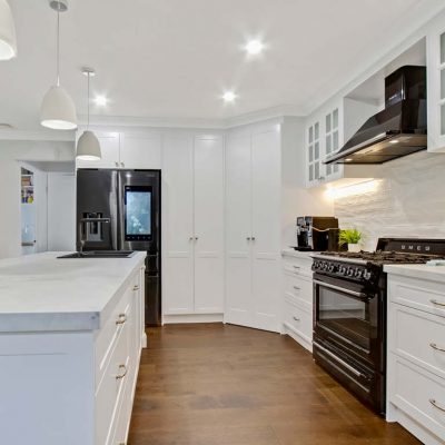 Ropes Crossing Shaker Kitchen with porcelain stone benchtop, silver handles, Black appliances and colonial overhead cupboards