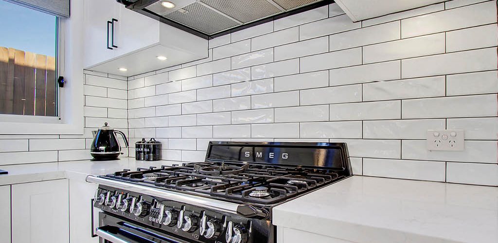 Schofields Clean White U Shaped Shaker Style Kitchen White Subway Tile Splashback Over Gas Cook Top and Stone